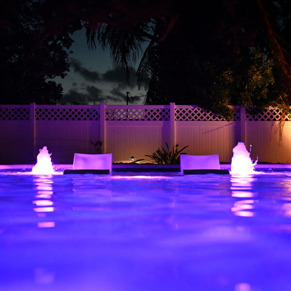 pool with chairs and lighting at night