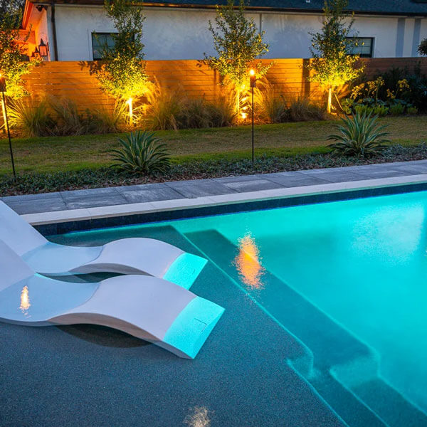 pool with chairs and lighting at night